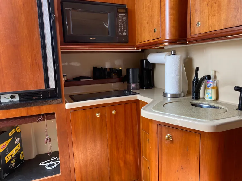 Slide: The Image of Compact kitchen in 2000 Cruisers 3672 yacht with wood cabinets, microwave, and sink. - 16