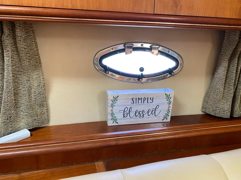 Slide: The Image of Interior of 2000 Cruisers 3672 yacht with porthole and "Simply Blessed" sign. - 20