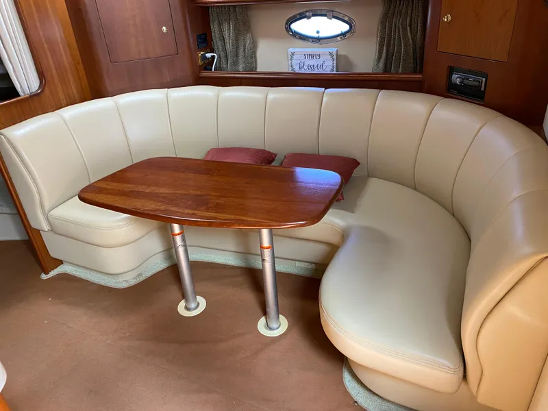 Slide: The Image of Luxurious 2000 Cruisers 3672 yacht interior with curved leather seating and wooden table. - 21