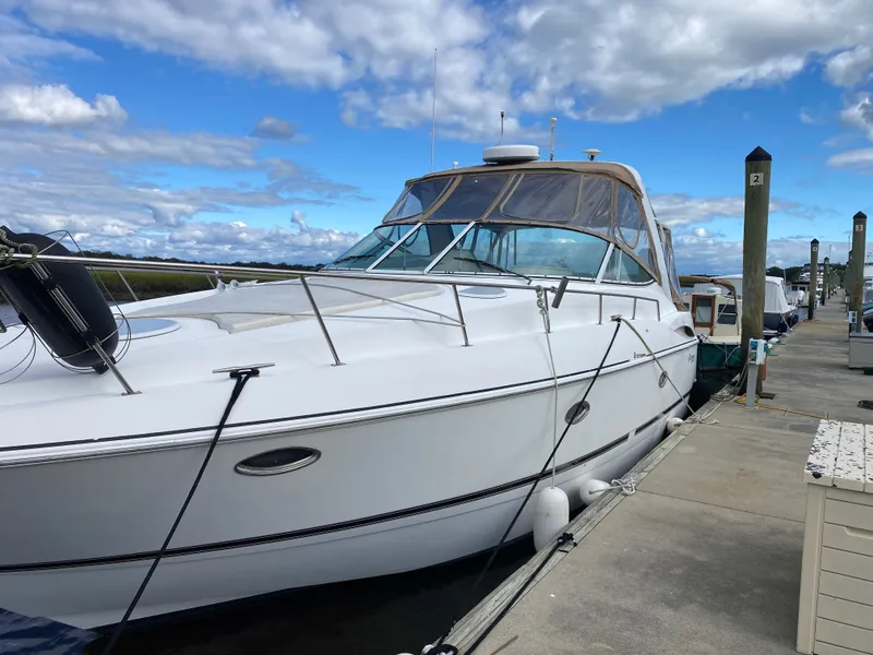 Slide: The Image of 2000 Cruisers 3672 yacht docked at marina under blue sky. - 4