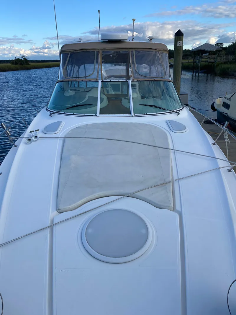 Slide: The Image of 2000 Cruisers 3672 yacht docked by a serene waterfront. - 7