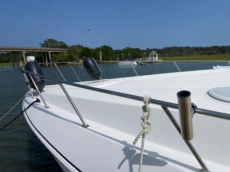 Slide: The Image of Cruisers 3672 yacht from 2000 docked near a scenic bridge and lush greenery. - 6