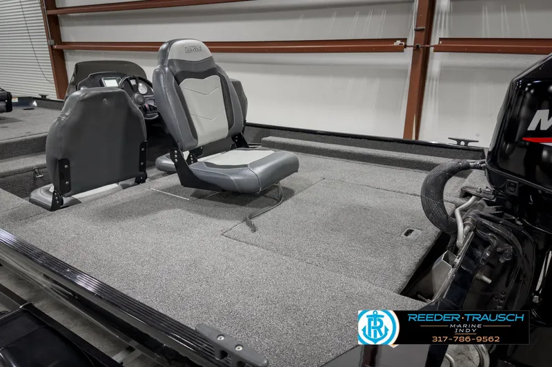 Slide: The Image of 2021 Lowe Skorpion 17 boat interior with seating and motor, in a showroom. - 22