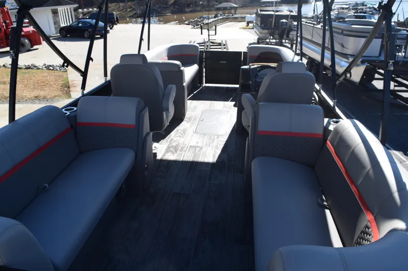 Slide: The Image of 2025 Qwest E-Class 824 RLS pontoon boat interior with gray seating and red accents. - 10
