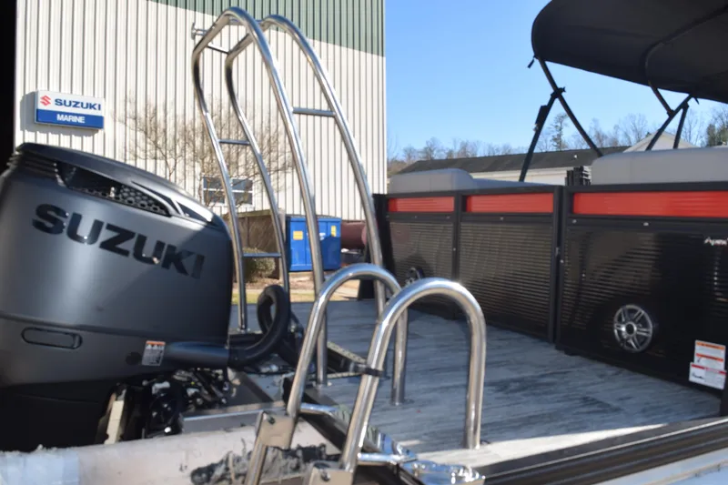 Slide: The Image of 2025 Qwest E-Class 824 RLS pontoon boat with Suzuki engine at marine dealership. - 5
