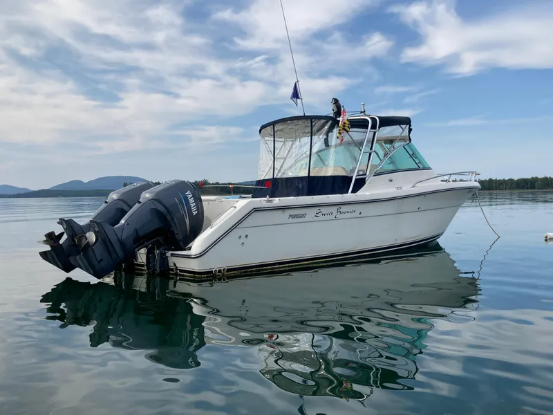 Slide: The Image of 2003 Pursuit 2670 Denali LS boat on calm water with twin outboard motors. - 0