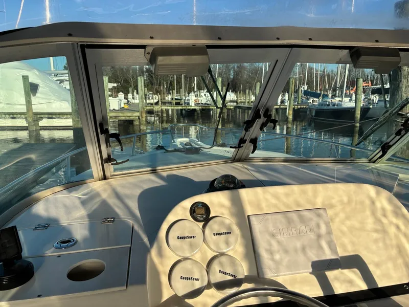 Slide: The Image of Interior view of 2003 Pursuit 2670 Denali LS boat cockpit with marina in background. - 17