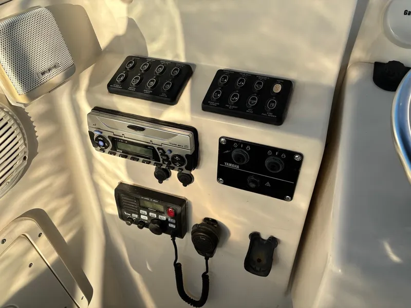 Slide: The Image of Control panel of a 2003 Pursuit 2670 Denali LS boat with various switches and devices. - 18