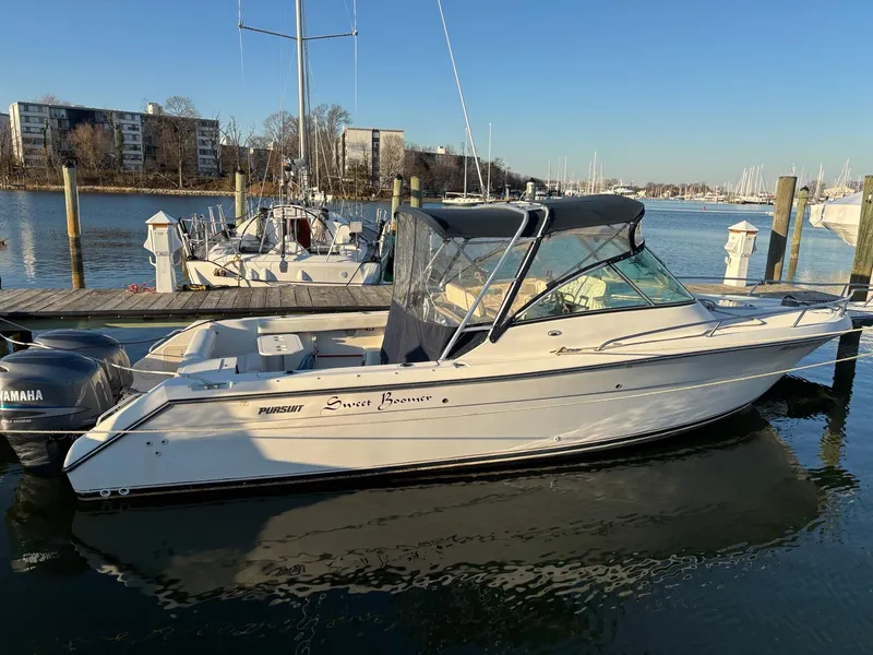 Slide: The Image of 2003 Pursuit 2670 Denali LS boat docked in a marina, clear sky background. - 2