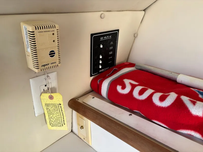 Slide: The Image of 2003 Pursuit 2670 Denali LS cabin interior with control panel and red blanket. - 24