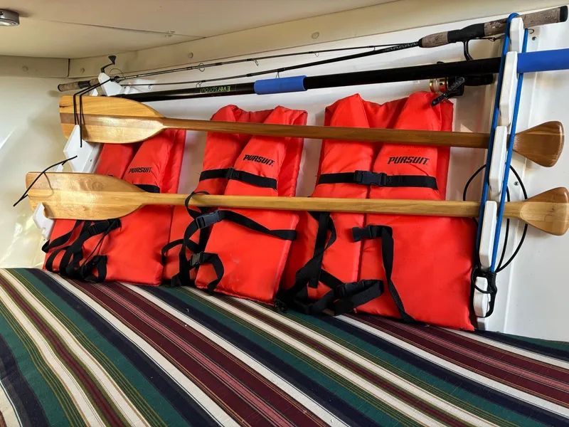 Slide: The Image of Orange life jackets and wooden paddles on a 2003 Pursuit 2670 Denali LS boat. - 25