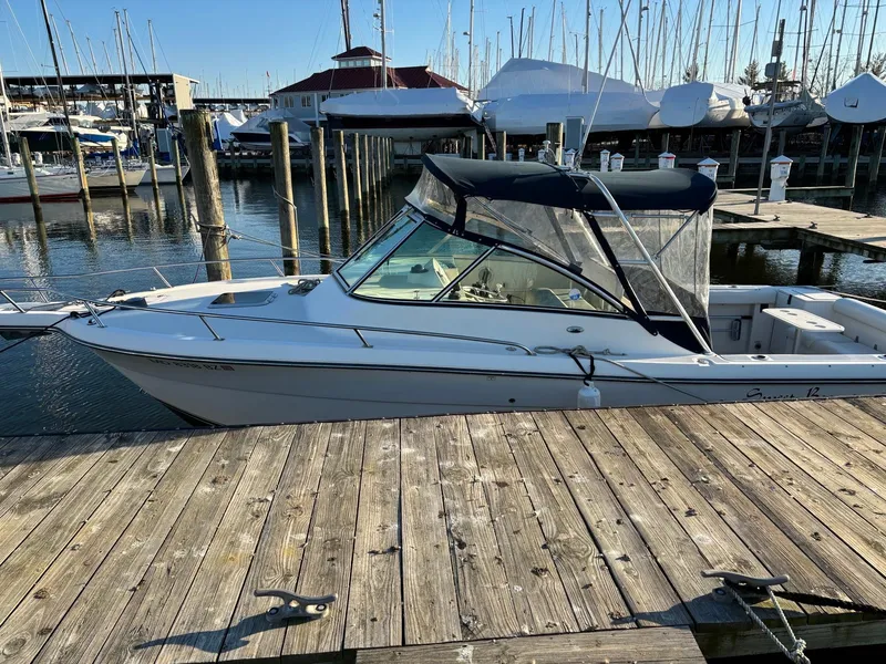 Slide: The Image of 2003 Pursuit 2670 Denali LS boat docked at a marina with sailboats in the background. - 5