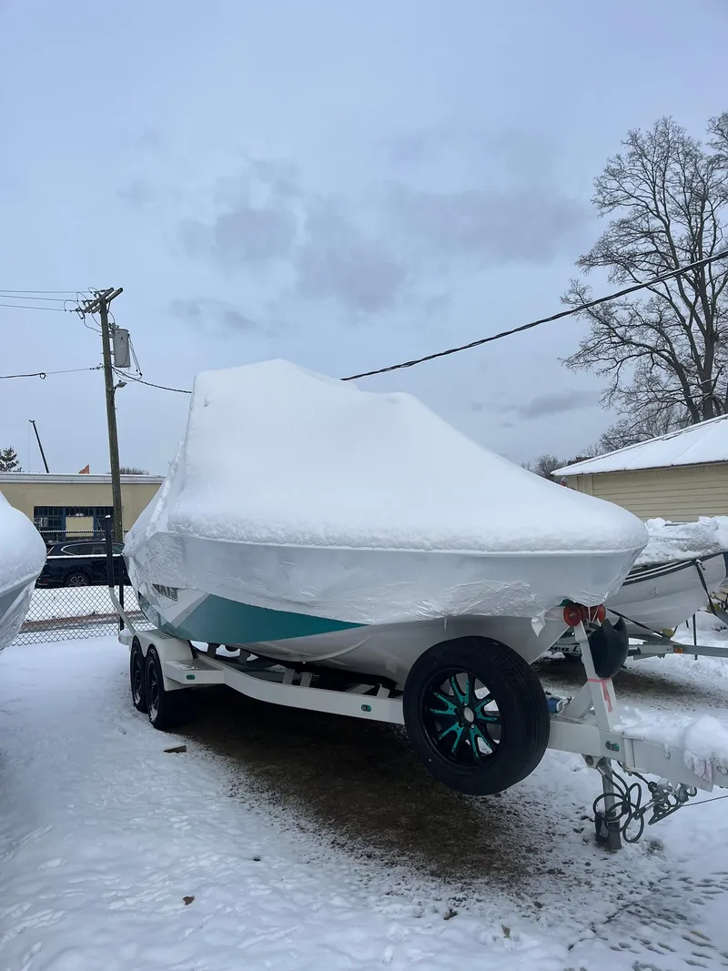 Slide: The Image of 2023 Axis T220 boat covered in snow, parked on a trailer in a snowy yard. - 9