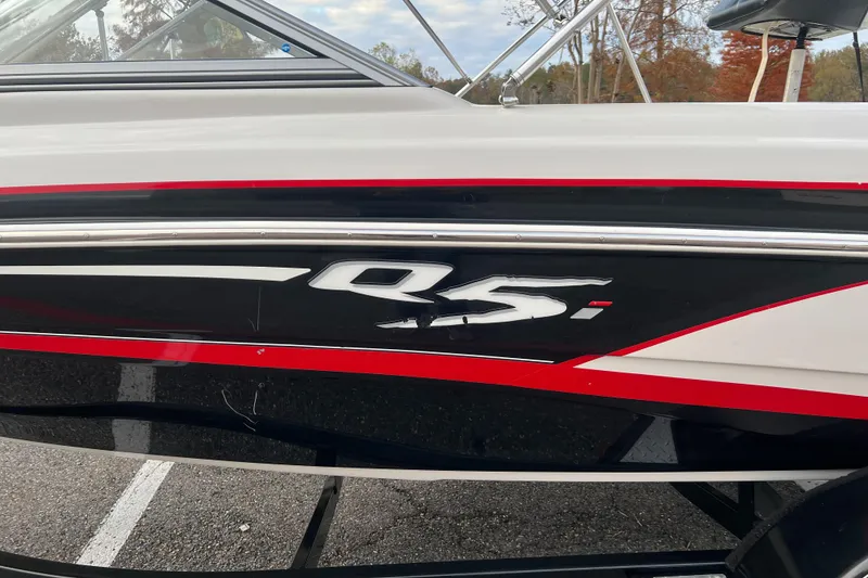 Slide: The Image of 2013 Tahoe Q5i boat side view with red and black detailing. - 13
