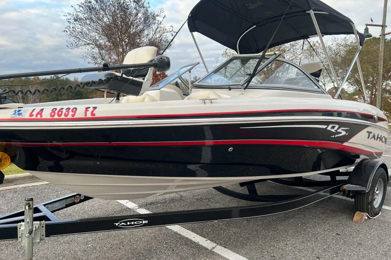 Slide: The Image of 2013 Tahoe Q5i boat on trailer with canopy, parked outdoors. - 3