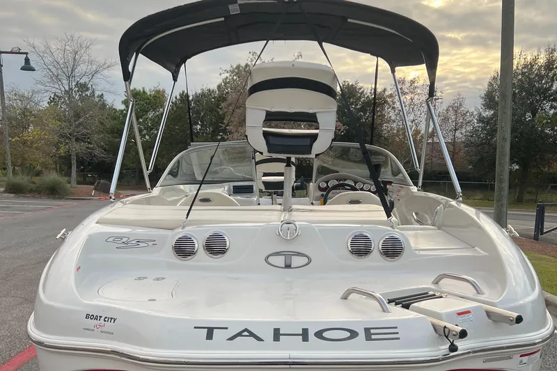 Slide: The Image of 2013 Tahoe Q5i boat with canopy, parked outdoors under cloudy sky. - 4
