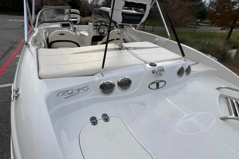 Slide: The Image of 2013 Tahoe Q5i boat interior with seating and dashboard, parked outdoors. - 5