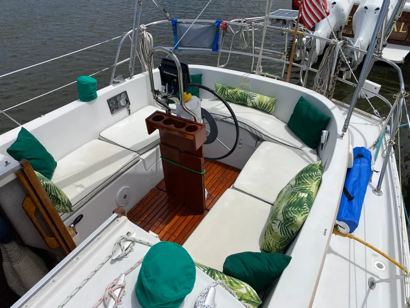 Slide: The Image of 1986 Nonsuch 30 Ultra sailboat cockpit with cushioned seating and wooden flooring. - 12