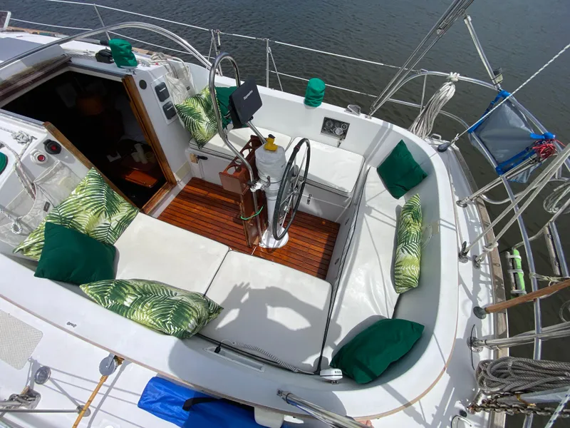 Slide: The Image of 1986 Nonsuch 30 Ultra sailboat cockpit with green cushions and wooden flooring. - 14