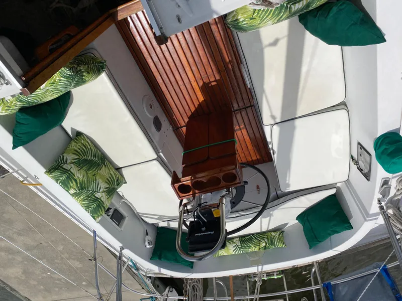 Slide: The Image of 1986 Nonsuch 30 Ultra sailboat cockpit with green cushions and wooden seating. - 17