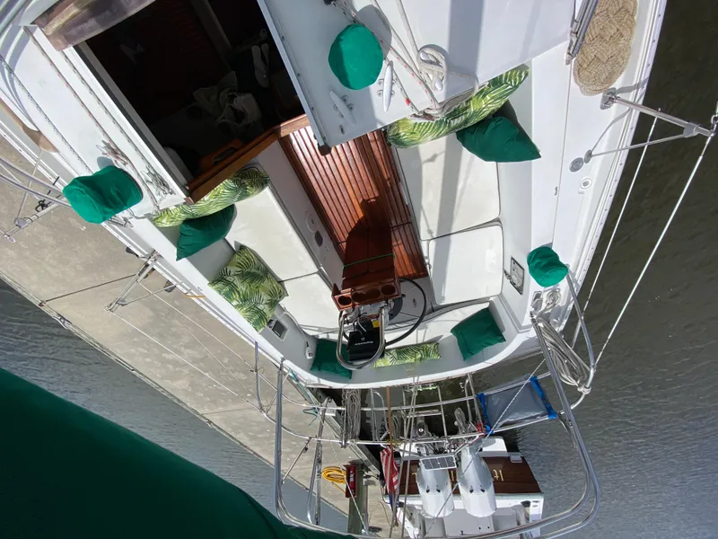 Slide: The Image of 1986 Nonsuch 30 Ultra sailboat with green cushions docked at marina. - 18