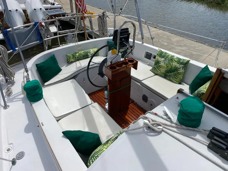 Slide: The Image of 1986 Nonsuch 30 Ultra sailboat cockpit with green cushions and wooden flooring. - 19