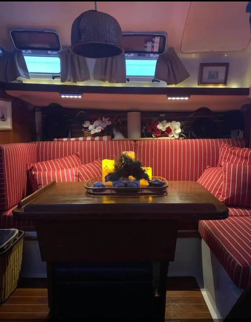 Slide: The Image of Cozy interior of 1986 Nonsuch 30 Ultra sailboat with striped seating and decorative accents. - 23
