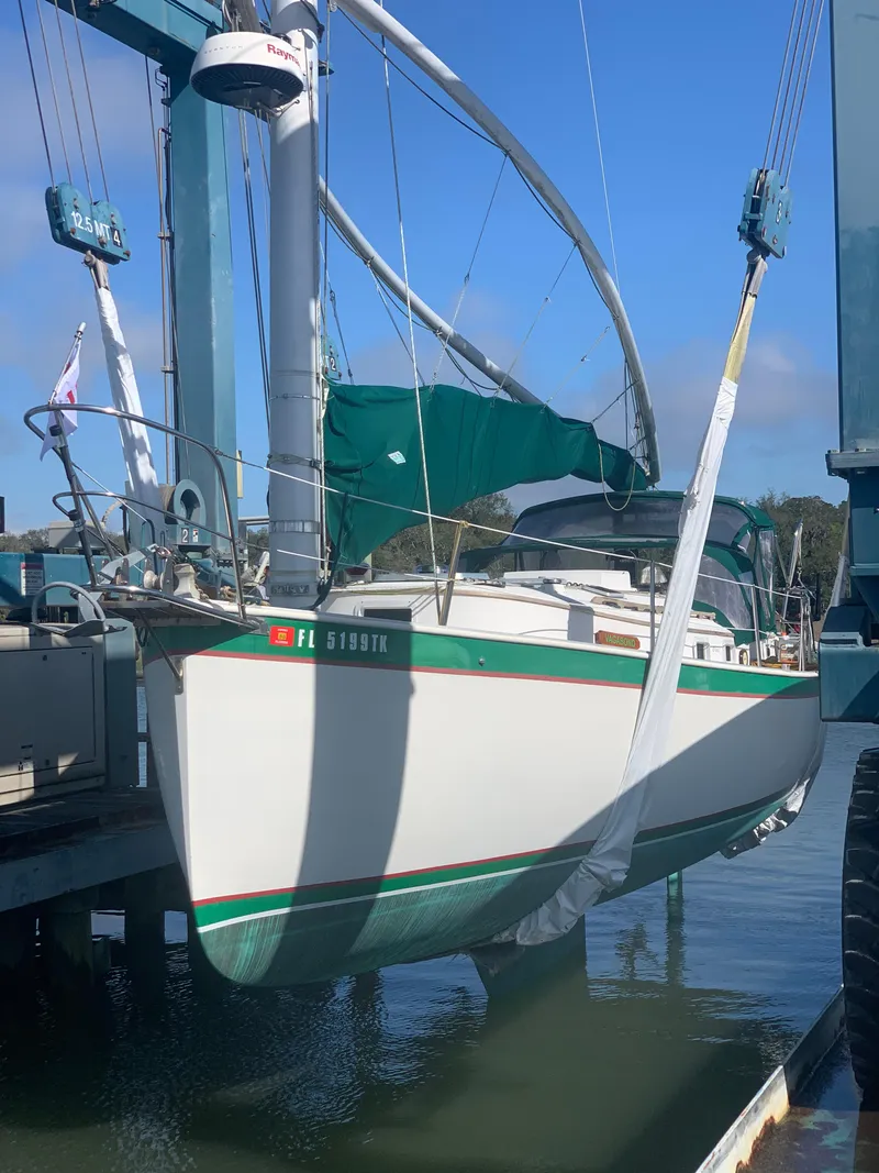 Slide: The Image of 1986 Nonsuch 30 Ultra sailboat in dry dock, green and white hull. - 24