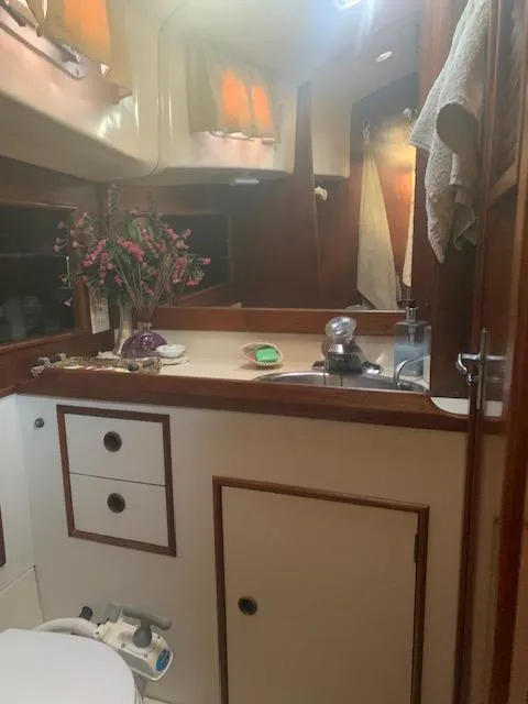 Slide: The Image of 1986 Nonsuch 30 Ultra yacht bathroom with wooden accents and floral decor. - 41
