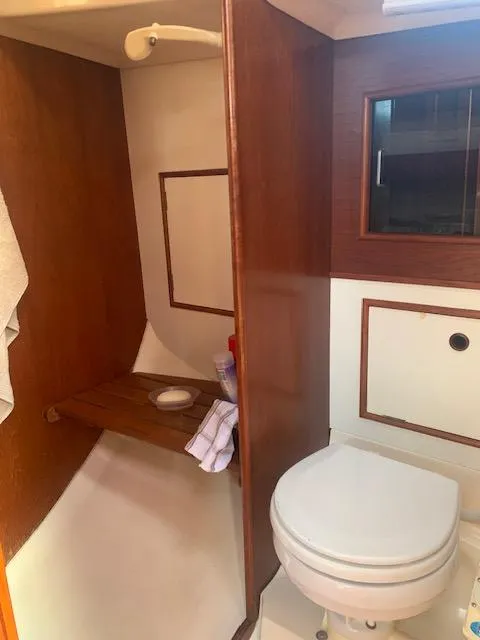 Slide: The Image of 1986 Nonsuch 30 Ultra yacht bathroom with wooden accents and white fixtures. - 42