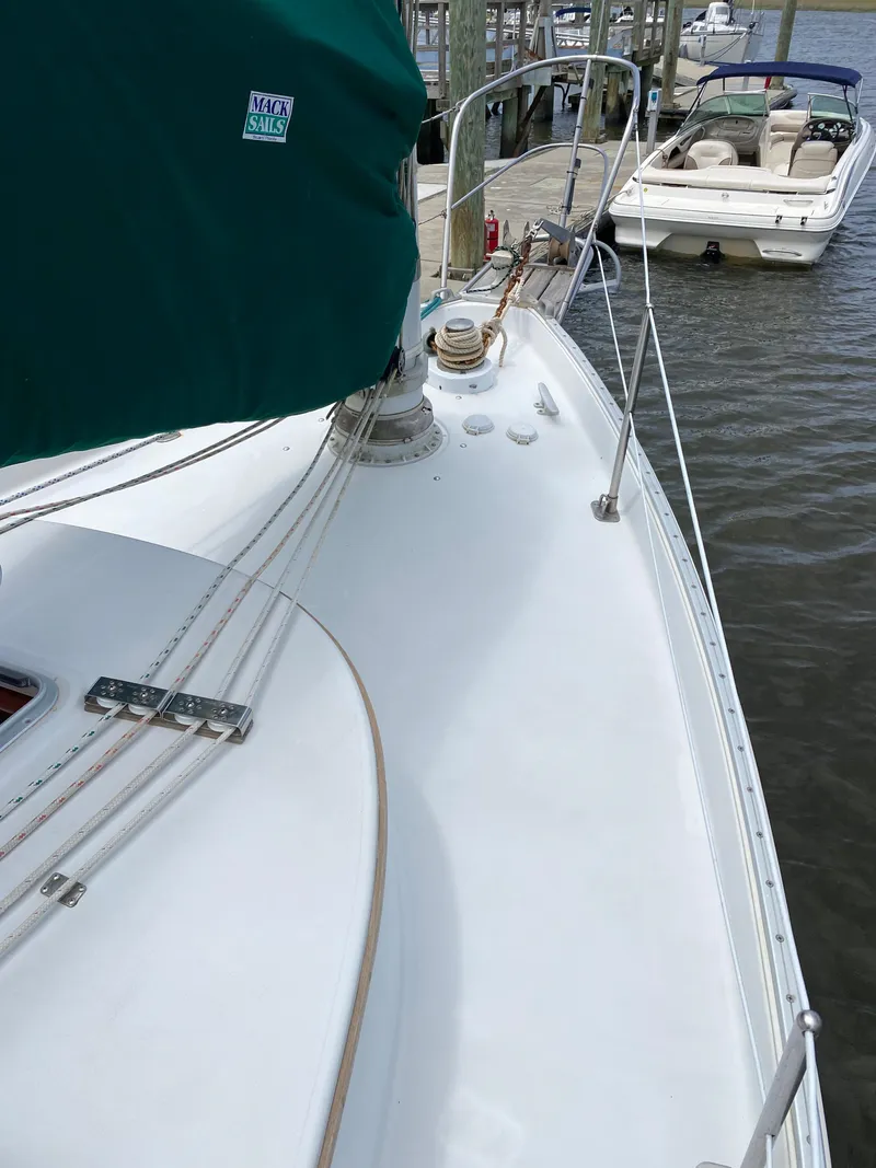 Slide: The Image of 1986 Nonsuch 30 Ultra sailboat docked, featuring a clean deck and green sail cover. - 9