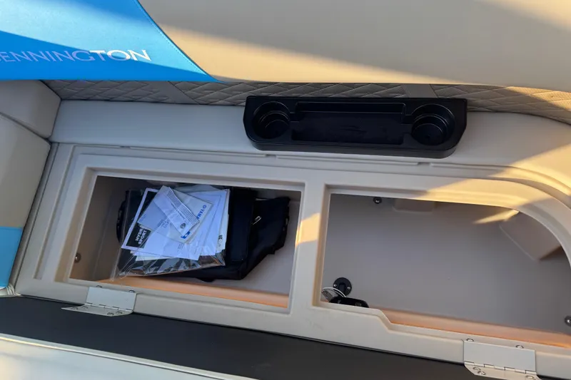 Slide: The Image of Interior storage compartment of 2025 Bennington 23 SSB boat with documents and cup holders. - 19