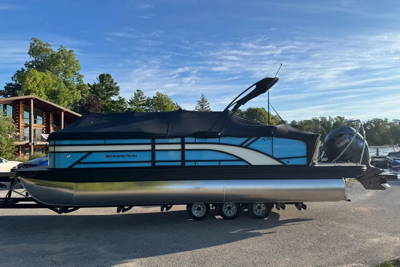 Slide: The Image of 2025 Bennington 23 SSB pontoon boat on trailer, covered, with Yamaha outboard motor. - 3
