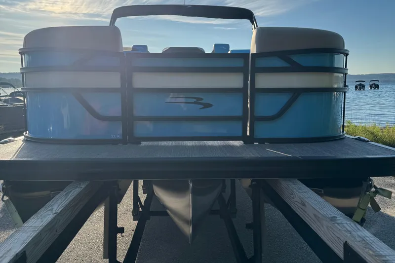 Slide: The Image of 2025 Bennington 23 SSB pontoon boat on trailer by a lake. - 6