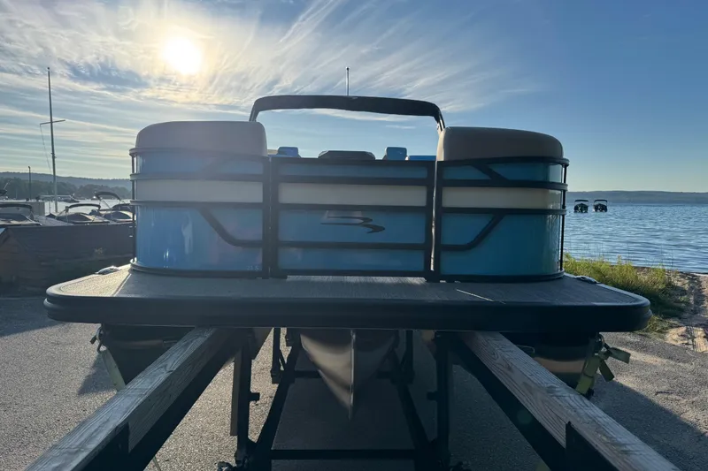Slide: The Image of 2025 Bennington 23 SSB pontoon boat on trailer at lakeside during sunset. - 7
