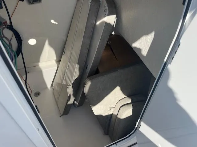 Slide: The Image of 2023 Sea Pro 219CC boat storage compartment with cushions and wiring. - 8
