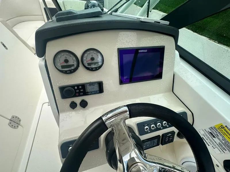 Slide: The Image of 2020 Boston Whaler 230 Vantage dashboard with steering wheel and navigation controls. - 18