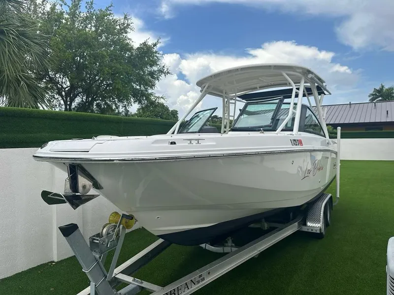 Slide: The Image of 2020 Boston Whaler 230 Vantage boat on trailer, parked on green lawn. - 4