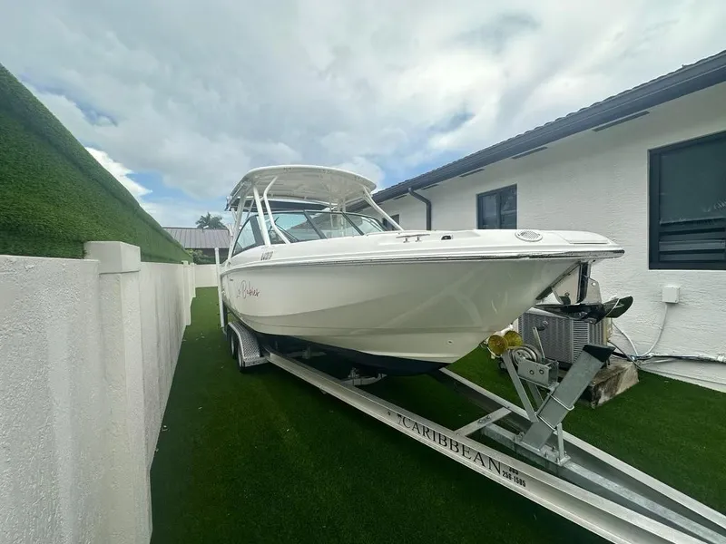 Slide: The Image of 2020 Boston Whaler 230 Vantage boat on trailer beside house. - 5