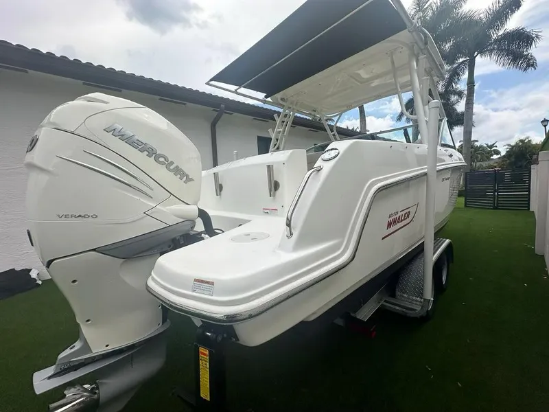 Slide: The Image of 2020 Boston Whaler 230 Vantage boat with Mercury Verado engine, parked on grass. - 7