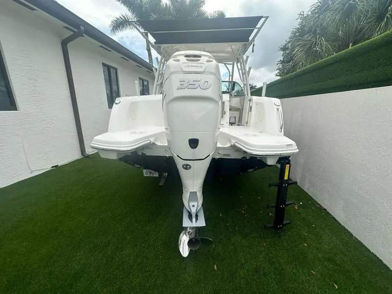 Slide: The Image of 2020 Boston Whaler 230 Vantage boat with powerful outboard motor, parked on grass. - 8