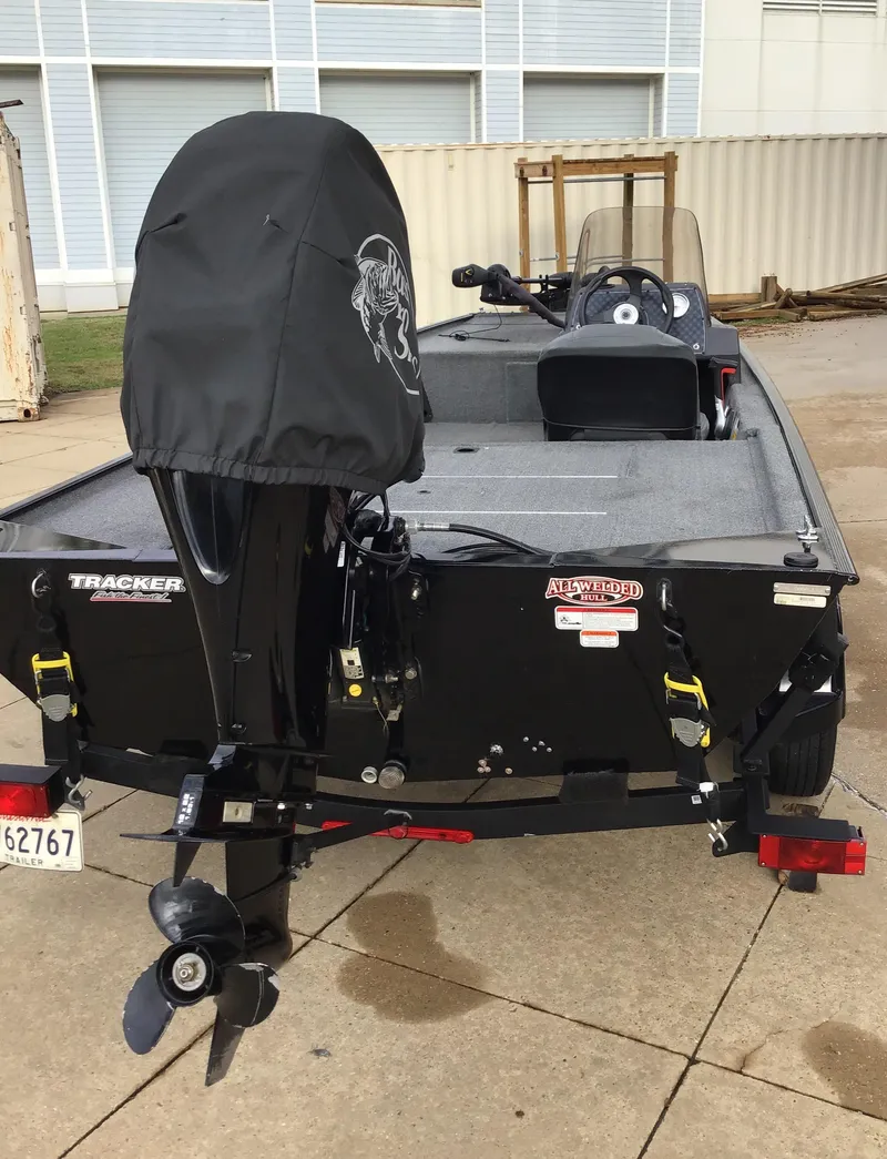 Slide: The Image of 2020 Tracker BASS TRK CL XL boat with covered motor, parked on concrete. - 4