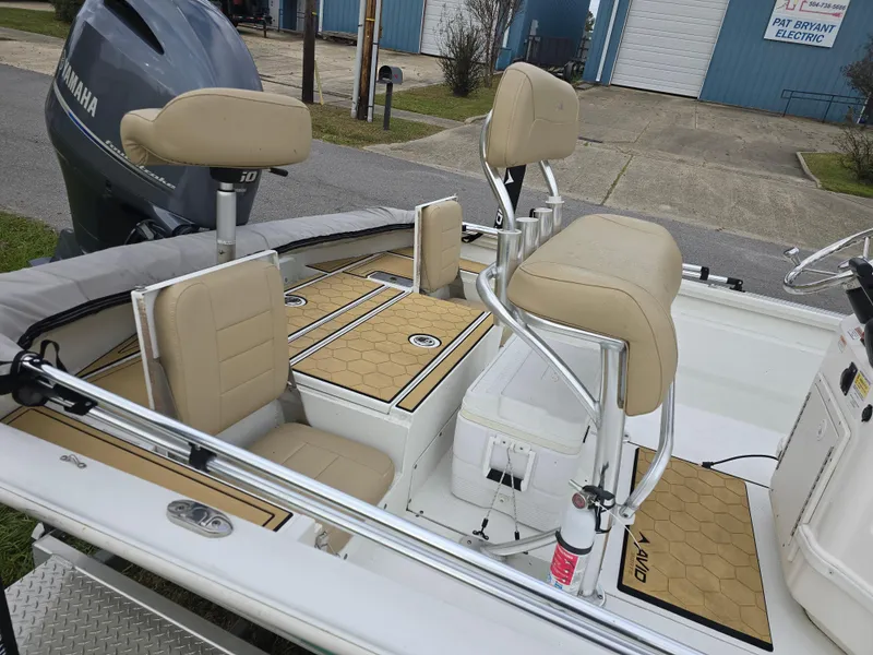 Slide: The Image of 2022 Avid 21 Mag boat interior with beige seating and Yamaha engine. - 10