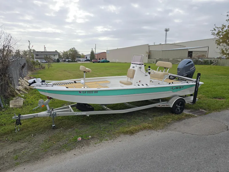 Slide: The Image of 2022 Avid 21 Mag boat with Yamaha 150 engine, parked on grass. - 14