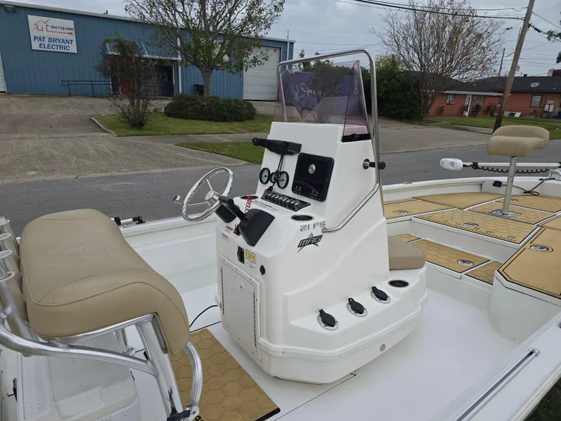 Slide: The Image of 2022 Avid 21 Mag boat console with steering wheel and controls, parked outdoors. - 21