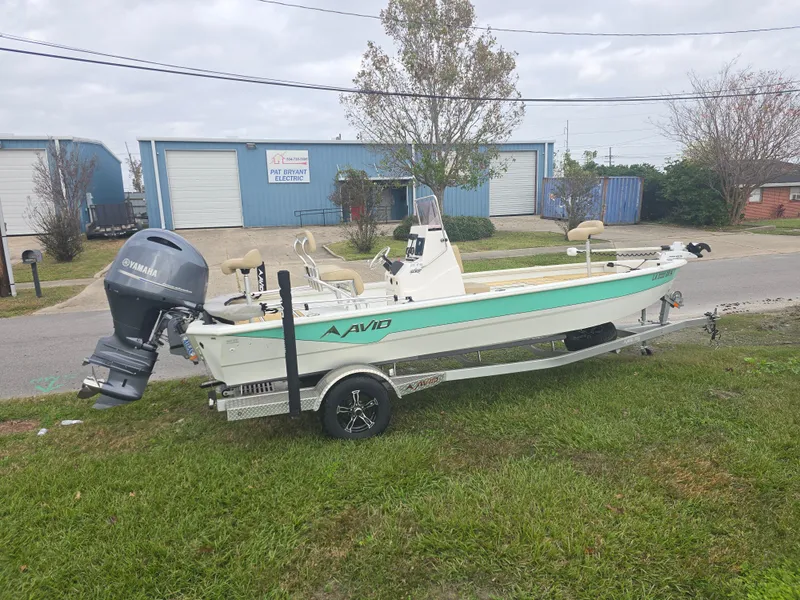 Slide: The Image of Avid 21 Mag 2022 boat on trailer with Yamaha outboard motor, parked on grass. - 3