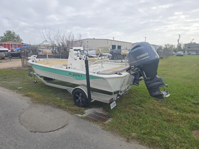 Slide: The Image of 2022 Avid 21 Mag boat with Yamaha outboard motor on trailer, parked on grass. - 6