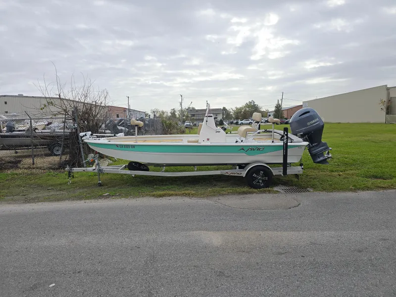 Slide: The Image of 2022 Avid 21 Mag boat on trailer, parked outdoors under cloudy sky. - 7