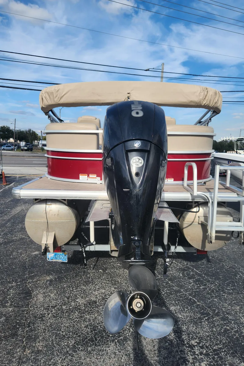 Slide: The Image of 2019 Sun Tracker 24 DLX Party Barge on trailer under sunny sky. - 3
