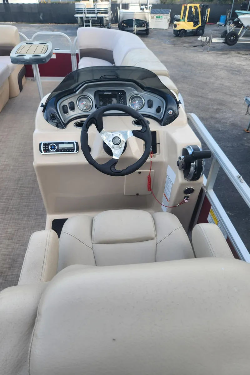 Slide: The Image of 2019 Sun Tracker 24 DLX Party Barge boat interior with steering console and seating. - 4